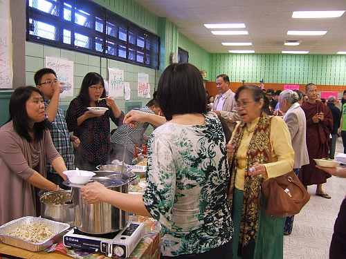 Young and old mingle over noodles at the Burmese New Year celebration.