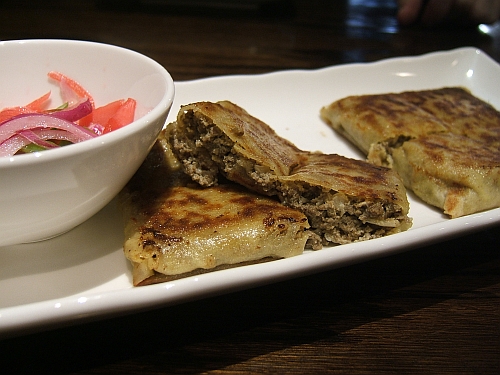 Murtabak, savory little packages of ground beef served with pickled onions.