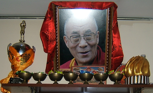 The Dalai Lama flanked by a basketball trophy and the Golden Momo.